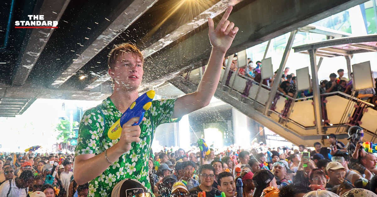 ภาพมุมสูงแสดงถนนสีลมเต็มไปด้วยผู้คนและกิจกรรมการเล่นน้ำในเทศกาลสงกรานต์อย่างคึกคัก