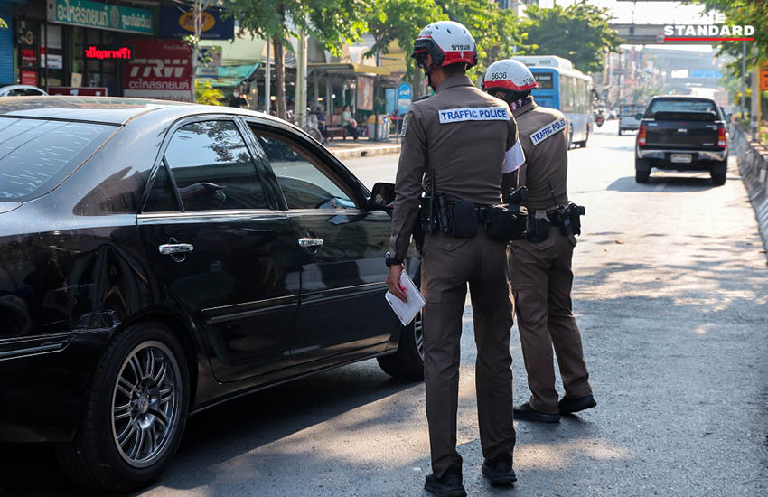 เจ้าหน้าที่ตำรวจกำลังกวดขันวินัยจราจรและตรวจสอบผู้ขับขี่ ณ จุดตรวจในวันแรกของการบังคับใช้กฎหมายใหม่ 1