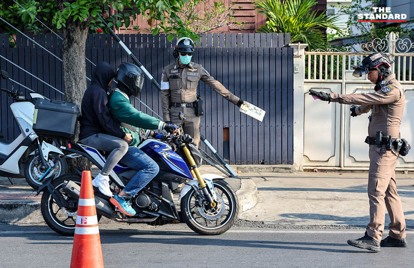 เจ้าหน้าที่ตำรวจกำลังกวดขันวินัยจราจรและตรวจสอบผู้ขับขี่ ณ จุดตรวจในวันแรกของการบังคับใช้กฎหมายใหม่ 2