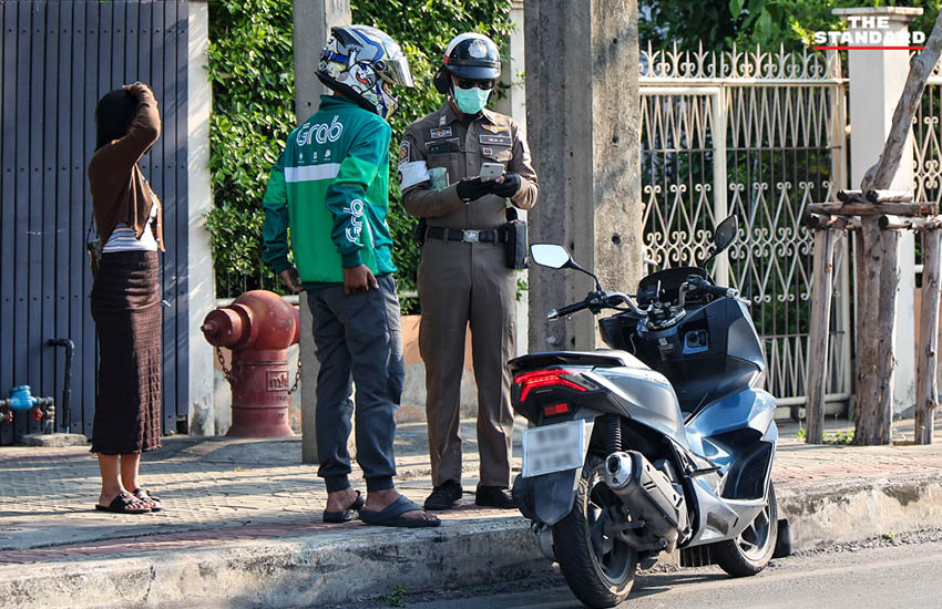 เจ้าหน้าที่ตำรวจกำลังกวดขันวินัยจราจรและตรวจสอบผู้ขับขี่ ณ จุดตรวจในวันแรกของการบังคับใช้กฎหมายใหม่ 5