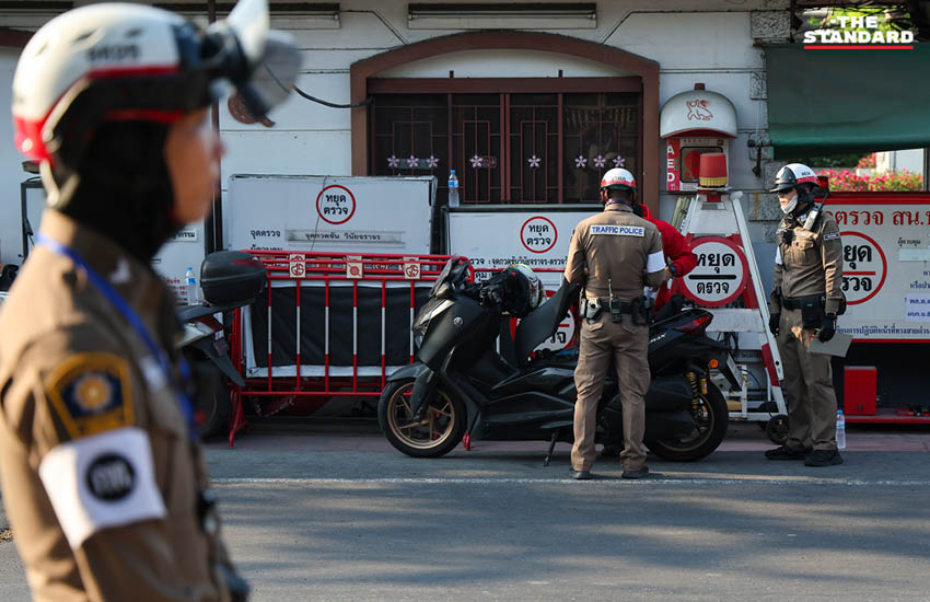 เจ้าหน้าที่ตำรวจกำลังกวดขันวินัยจราจรและตรวจสอบผู้ขับขี่ ณ จุดตรวจในวันแรกของการบังคับใช้กฎหมายใหม่ 9