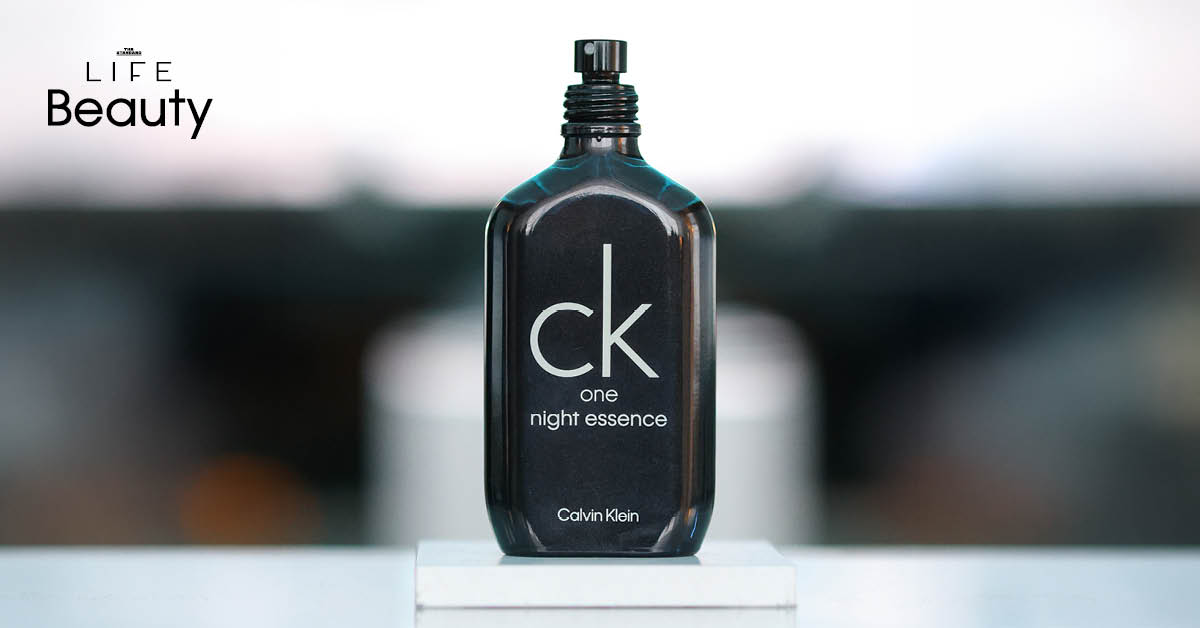 ภาพขวดน้ำหอม CK One Night Essence สีน้ำเงินเข้มโปร่งแสงคู่กับ ซี-พฤกษ์ พานิช