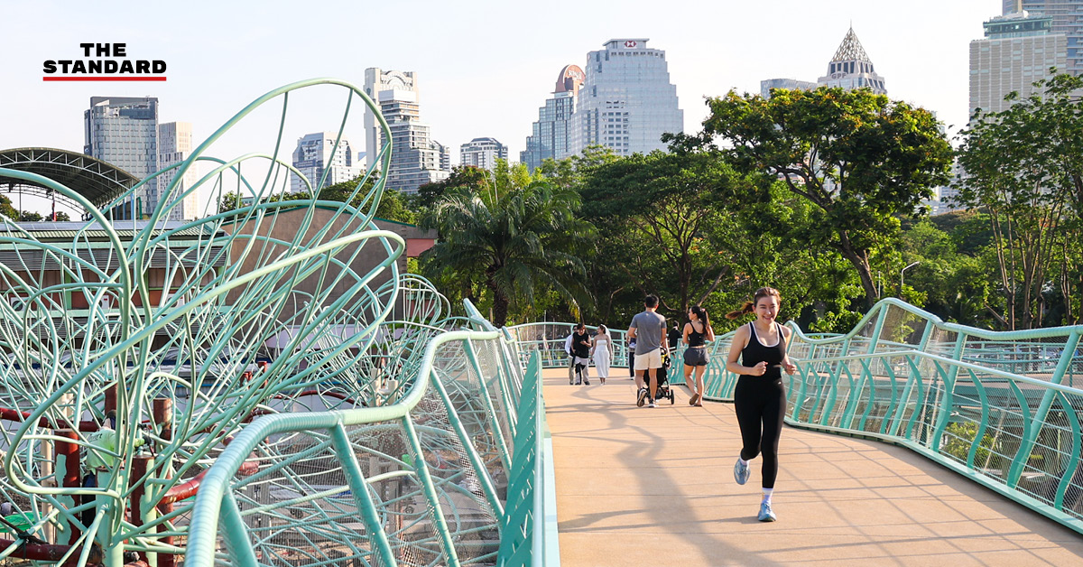 ภาพมุมสูงของสะพานเขียวโฉมใหม่ที่เชื่อมต่อสวนลุมพินีและสวนเบญจกิติ มีผู้คนเดินและวิ่งออกกำลังกาย