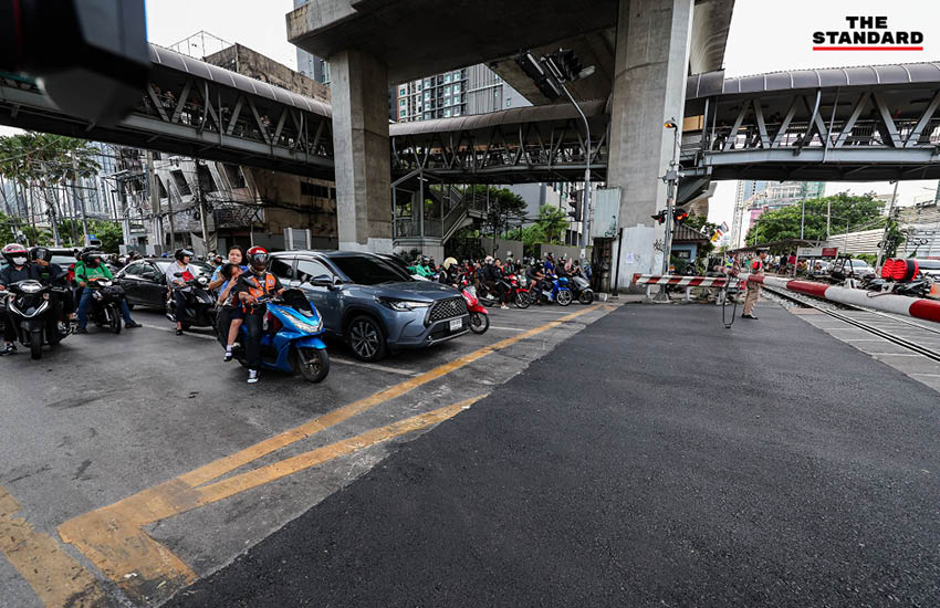 ภาพมุมสูงจุดตัดทางรถไฟมักกะสัน ที่มีการลาดยางมะตอยใหม่และเพิ่มเจ้าหน้าที่ควบคุมไม้กั้น 6