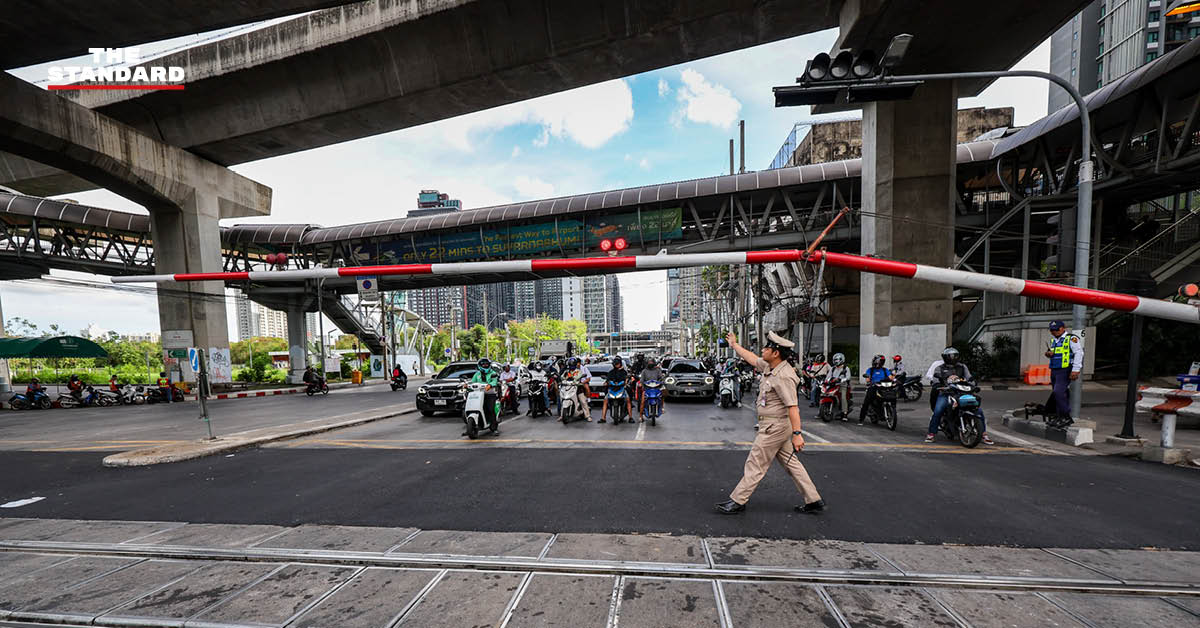 ภาพมุมสูงจุดตัดทางรถไฟมักกะสัน ที่มีการลาดยางมะตอยใหม่และเพิ่มเจ้าหน้าที่ควบคุมไม้กั้น