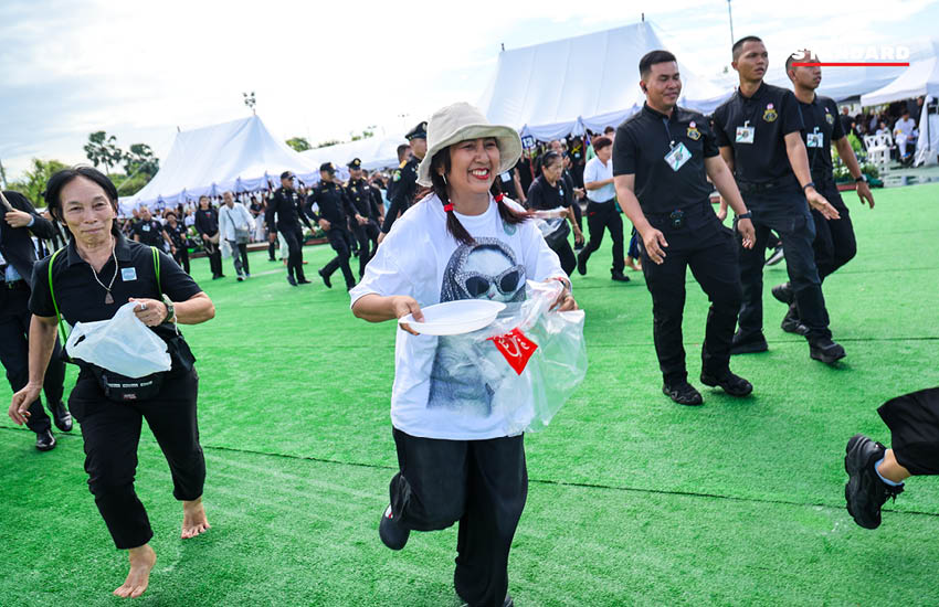 ประชาชนกำลังเก็บเมล็ดพันธุ์ข้าวพระราชทานบริเวณมณฑลพิธีท้องสนามหลวงหลังเสร็จสิ้นพระราชพิธีพืชมงคล 11