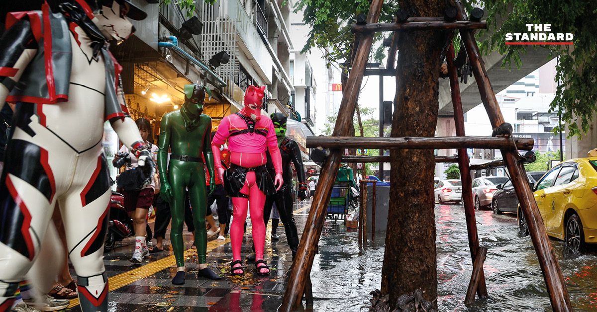 ภาพน้ำท่วมขังบนถนนสีลม มีหนูและผู้คนเดินฝ่าสายฝนในวันจัดกิจกรรม Bangkok Pride Parade