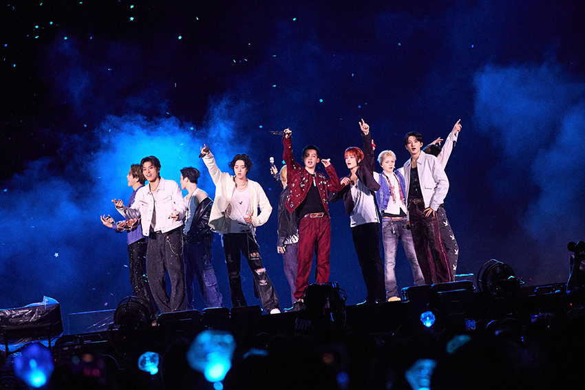 ภาพมุมกว้างของวง TREASURE กำลังแสดงคอนเสิร์ตบนเวทีขนาดใหญ่ท่ามกลางแฟนเพลงและแท่งไฟสีฟ้าเต็มสนามศุภชลาศัย 1