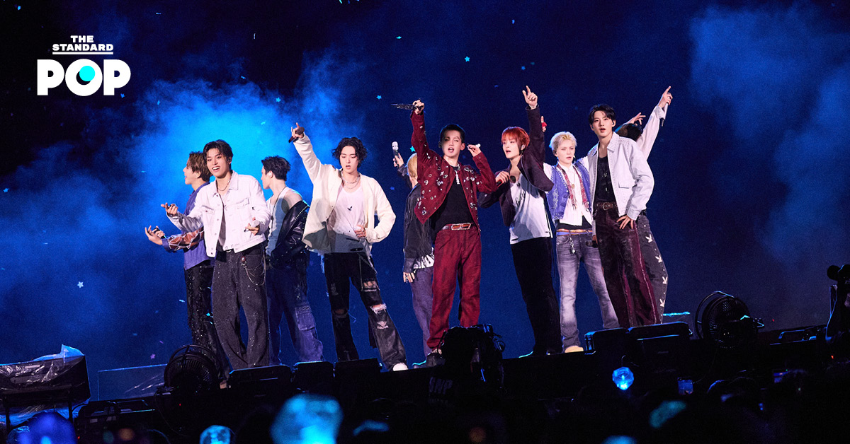 ภาพมุมกว้างของวง TREASURE กำลังแสดงคอนเสิร์ตบนเวทีขนาดใหญ่ท่ามกลางแฟนเพลงและแท่งไฟสีฟ้าเต็มสนามศุภชลาศัย