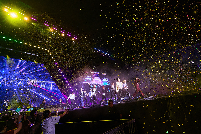 ภาพมุมกว้างของวง TREASURE กำลังแสดงคอนเสิร์ตบนเวทีขนาดใหญ่ท่ามกลางแฟนเพลงและแท่งไฟสีฟ้าเต็มสนามศุภชลาศัย 3