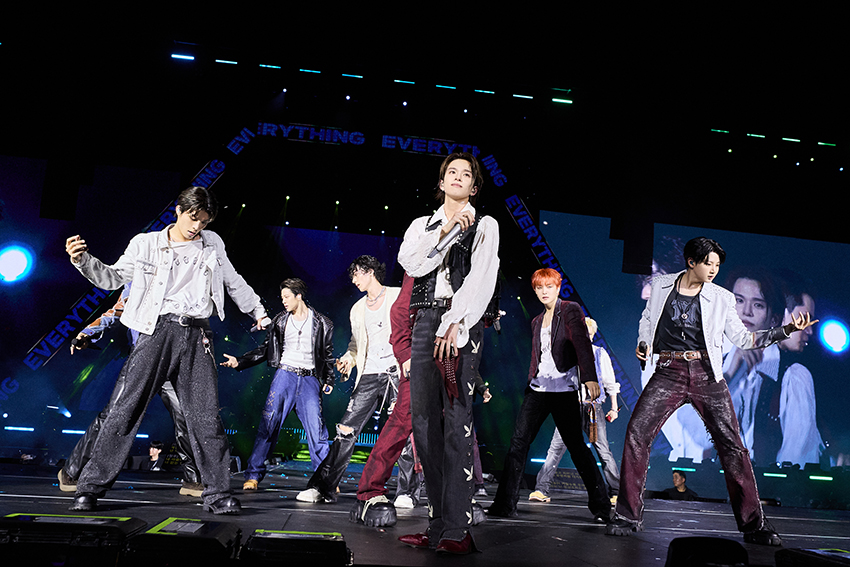 ภาพมุมกว้างของวง TREASURE กำลังแสดงคอนเสิร์ตบนเวทีขนาดใหญ่ท่ามกลางแฟนเพลงและแท่งไฟสีฟ้าเต็มสนามศุภชลาศัย 5