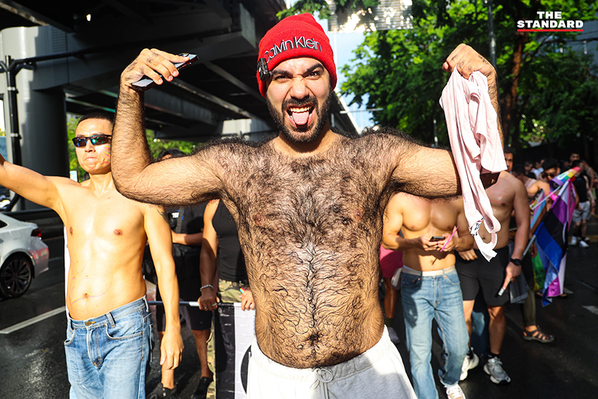 ผู้คนร่วมเดินขบวน Bangkok Pride Parade 2026 พร้อมธงสีรุ้งและป้ายหาเสียงของผู้สมัคร 12