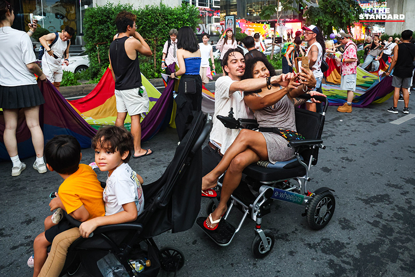ผู้คนร่วมเดินขบวน Bangkok Pride Parade 2026 พร้อมธงสีรุ้งและป้ายหาเสียงของผู้สมัคร 18