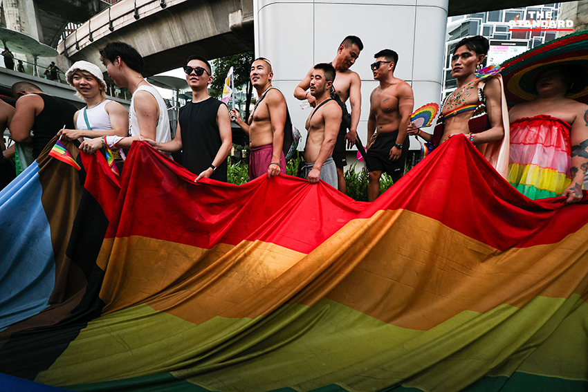 ผู้คนร่วมเดินขบวน Bangkok Pride Parade 2026 พร้อมธงสีรุ้งและป้ายหาเสียงของผู้สมัคร 21