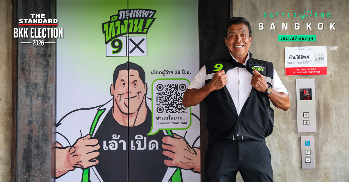ชัชชาติ สิทธิพันธุ์ ผู้สมัครผู้ว่าฯ กทม. ทำท่าสัญลักษณ์เบอร์ 9 พร้อมป้ายหาเสียงศิลปะ