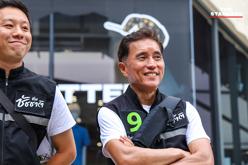 ชัชชาติ สิทธิพันธุ์ ผู้สมัครผู้ว่าฯ กทม. ทำท่าสัญลักษณ์เบอร์ 9 พร้อมป้ายหาเสียงศิลปะ 9