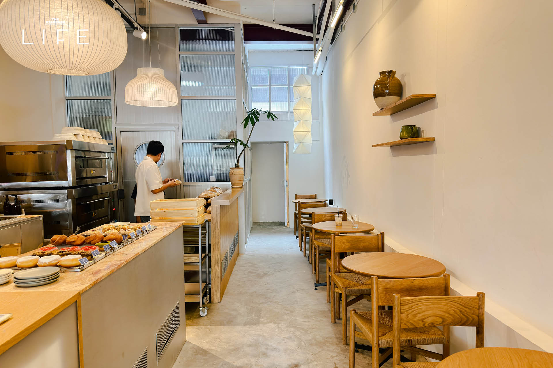 ภาพมุมกว้างของร้าน Drop By Dough สาขาสวนลุมพินี ที่ตกแต่งสไตล์มินิมัลด้วยปูนเปลือยและไม้ 3