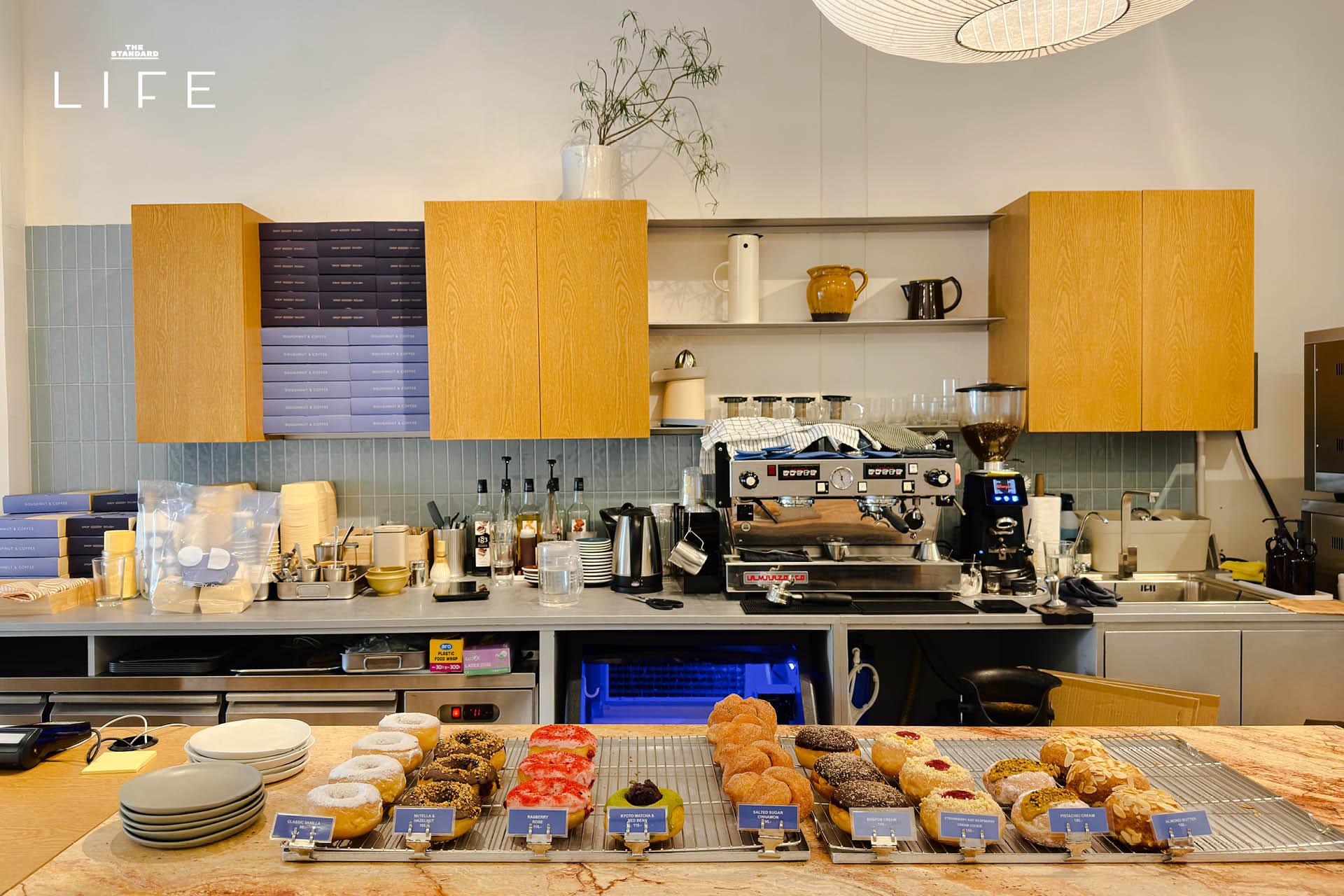 ภาพมุมกว้างของร้าน Drop By Dough สาขาสวนลุมพินี ที่ตกแต่งสไตล์มินิมัลด้วยปูนเปลือยและไม้ 6