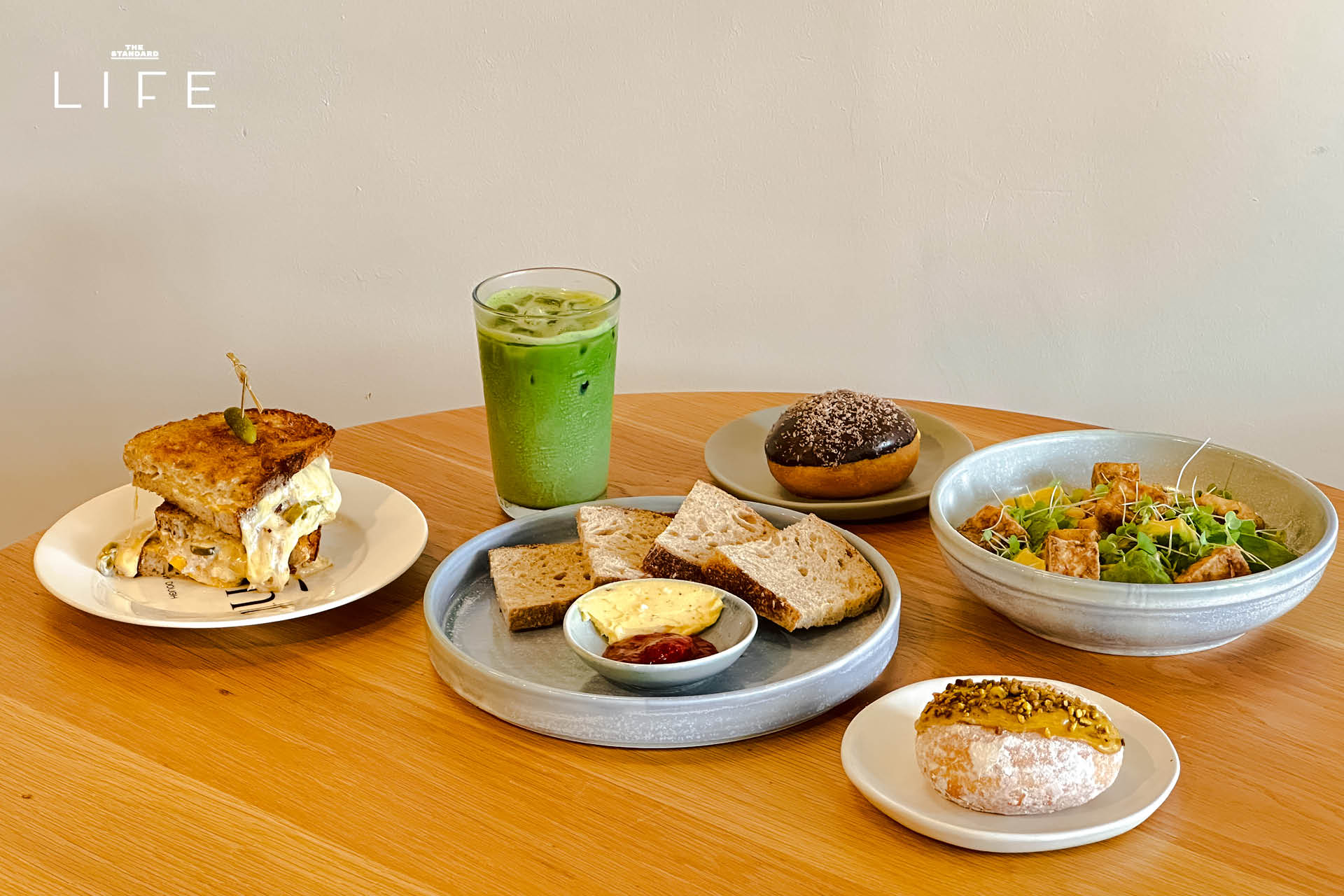 ภาพมุมกว้างของร้าน Drop By Dough สาขาสวนลุมพินี ที่ตกแต่งสไตล์มินิมัลด้วยปูนเปลือยและไม้ 7