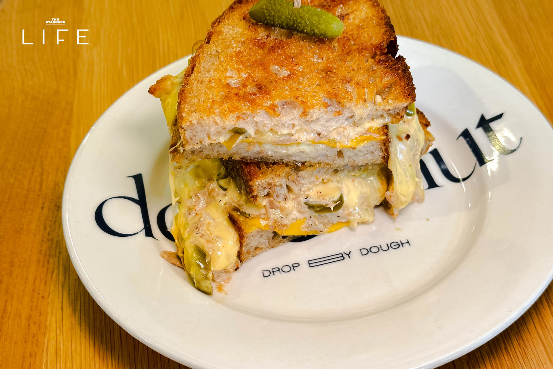 ภาพมุมกว้างของร้าน Drop By Dough สาขาสวนลุมพินี ที่ตกแต่งสไตล์มินิมัลด้วยปูนเปลือยและไม้ 8