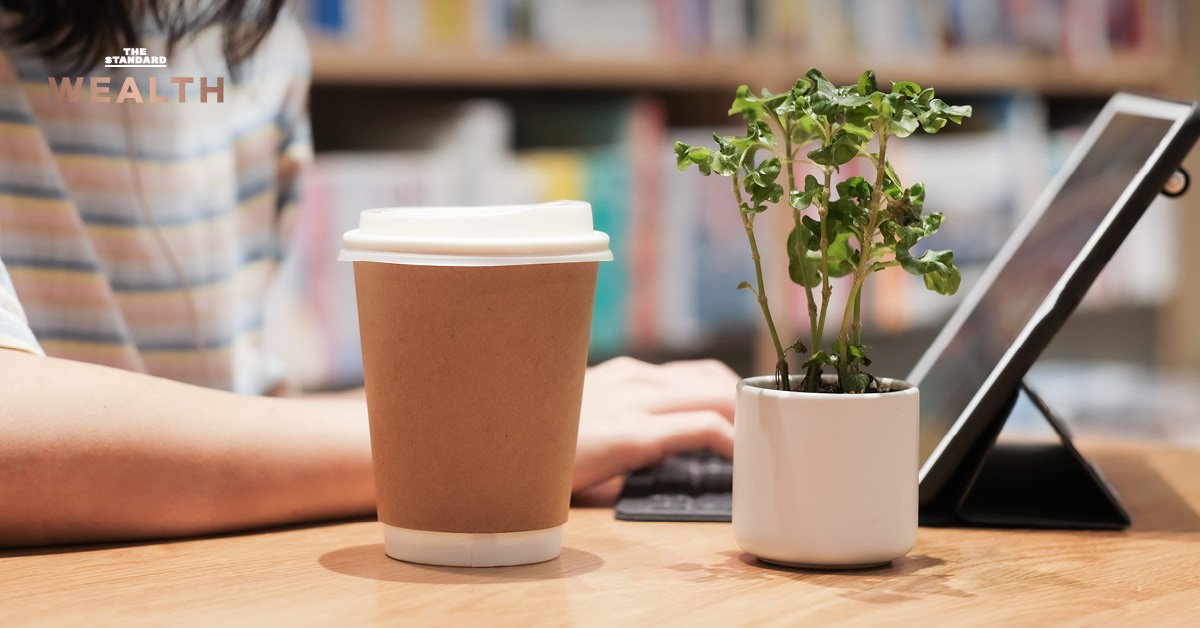 ภาพผู้หญิงเอเชียกำลังทำงานพร้อมแก้วกาแฟกระดาษ โดยมีข้อความ ธอส. ปรับเกมปล่อยกู้บ้าน ใช้ Credit Scoring ดึงฟรีแลนซ์-คนรุ่นใหม่