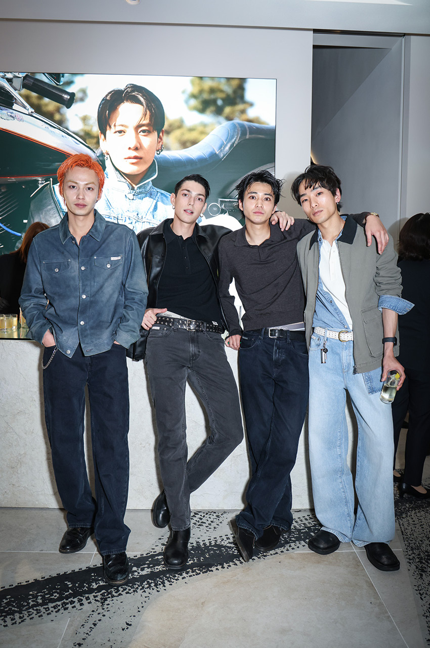 Jung Kook ในชุดแจ็กเกตหนังดีไซน์เรซซิงจาก Calvin Klein ยืนอยู่ภายในงานอีเวนต์ที่แฟล็กชิปสโตร์ฮาราจูกุ 6