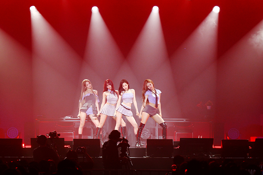 ภาพสี่สาววง KISS OF LIFE ในชุดธีมนักสืบสาวบนเวทีงานแฟนมีตติ้งที่กรุงเทพฯ 1