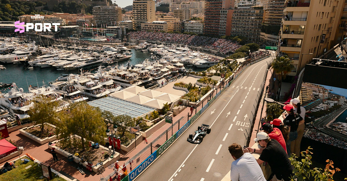 ผู้คนกำลังชมการแข่งขันรถ F1 จากระเบียงห้องพักโรงแรมที่มองเห็นสนามแข่งและท่าเรือยอชต์