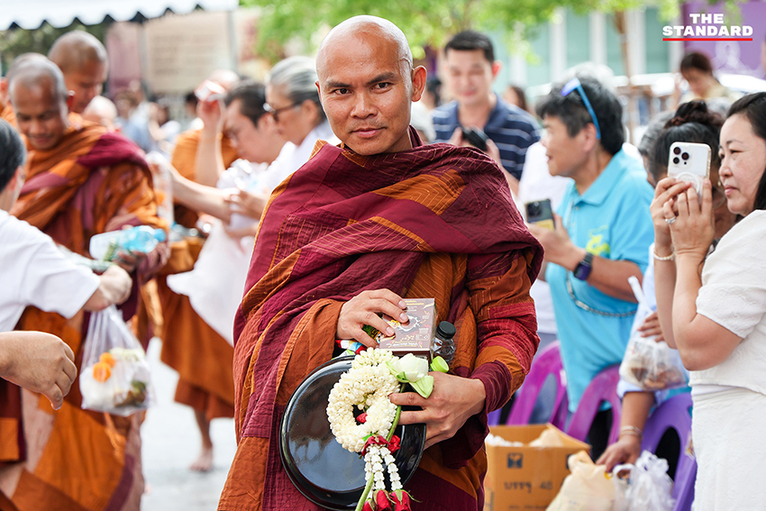 ภาพพุทธศาสนิกชนกำลังตักบาตรคณะพระสงฆ์ธุดงค์ธรรมยาตราที่วัดนาคปรก 1