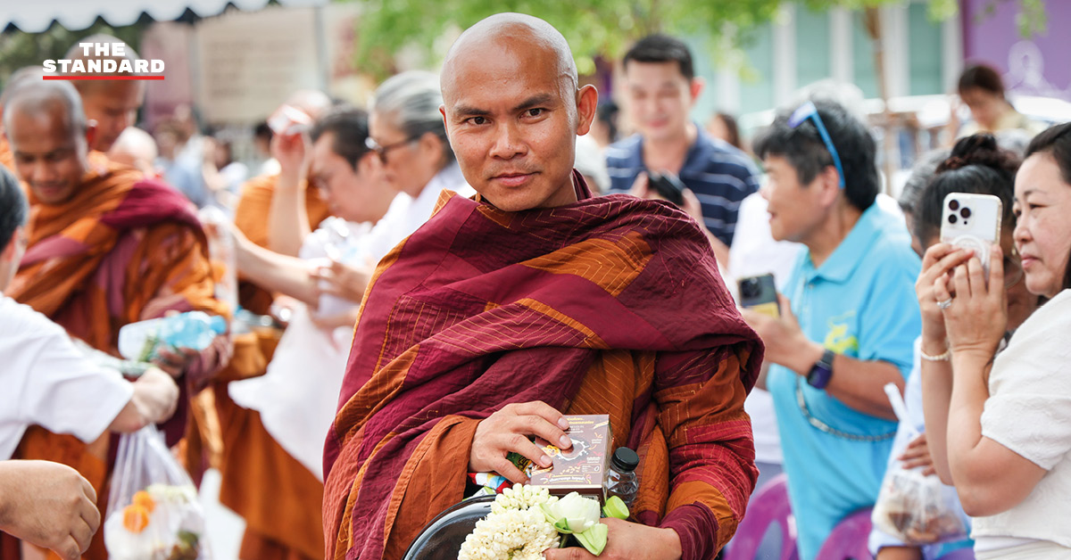 ภาพพุทธศาสนิกชนกำลังตักบาตรคณะพระสงฆ์ธุดงค์ธรรมยาตราที่วัดนาคปรก