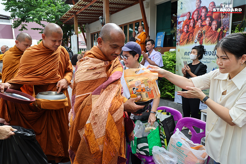 ภาพพุทธศาสนิกชนกำลังตักบาตรคณะพระสงฆ์ธุดงค์ธรรมยาตราที่วัดนาคปรก 3