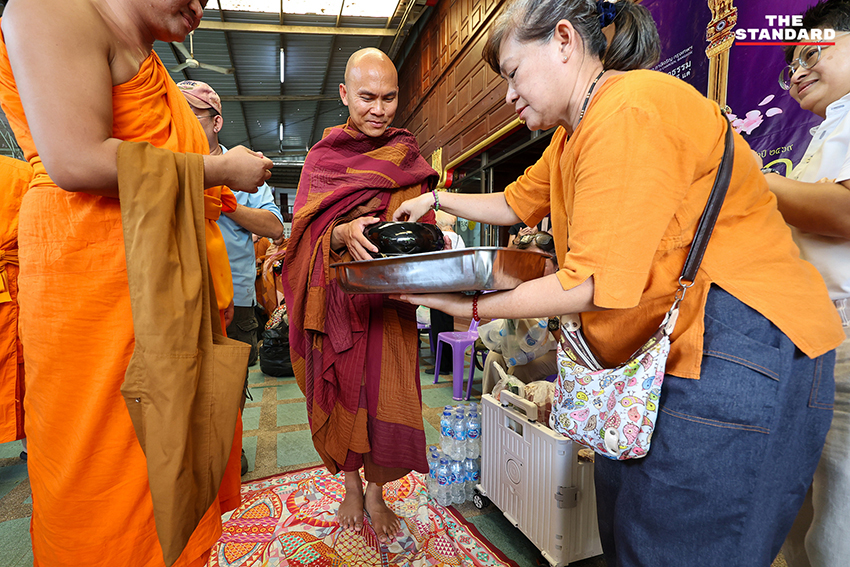 ภาพพุทธศาสนิกชนกำลังตักบาตรคณะพระสงฆ์ธุดงค์ธรรมยาตราที่วัดนาคปรก 4