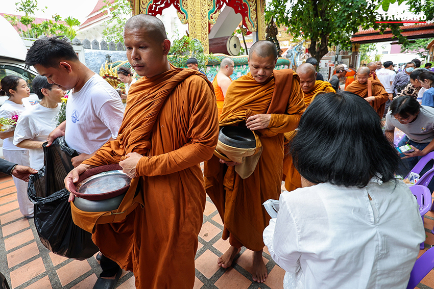 ภาพพุทธศาสนิกชนกำลังตักบาตรคณะพระสงฆ์ธุดงค์ธรรมยาตราที่วัดนาคปรก 5