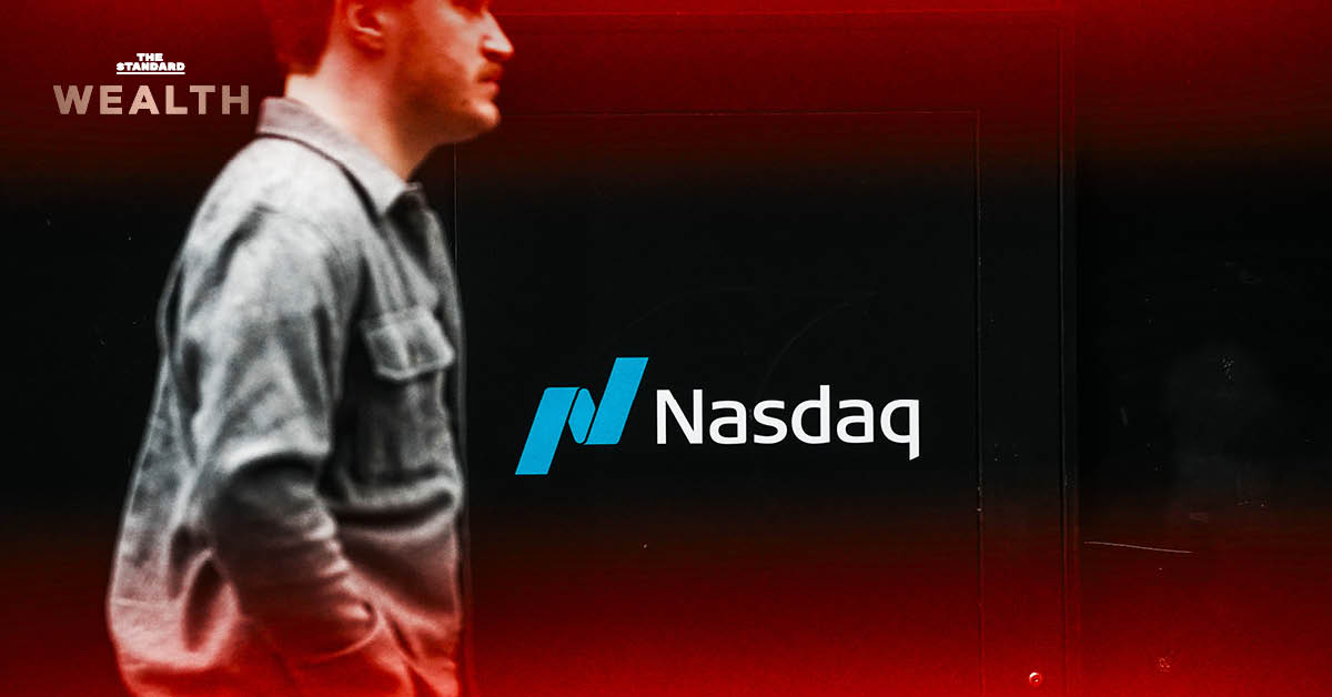 ชายคนหนึ่งเดินผ่านโลโก้ Nasdaq บนอาคารของบริษัท