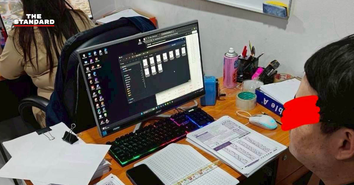 ภาพโต๊ะทำงาน มีคอมพิวเตอร์และเอกสารวางอยู่