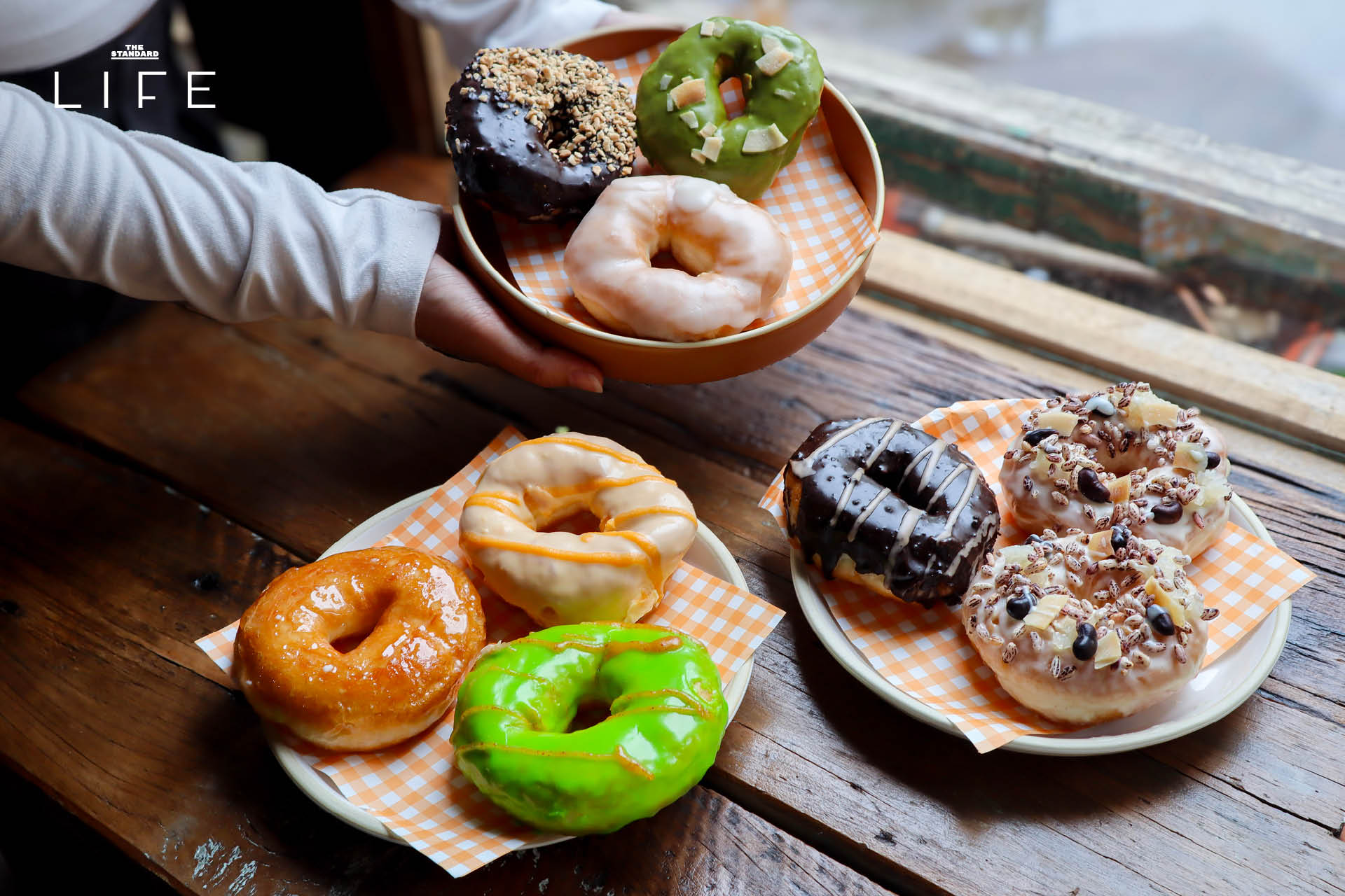 ภาพโดนัทโฮมเมด SODO Donut ที่ทำจากวัตถุดิบท้องถิ่น วางเรียงบนโต๊ะอย่างสวยงาม 10