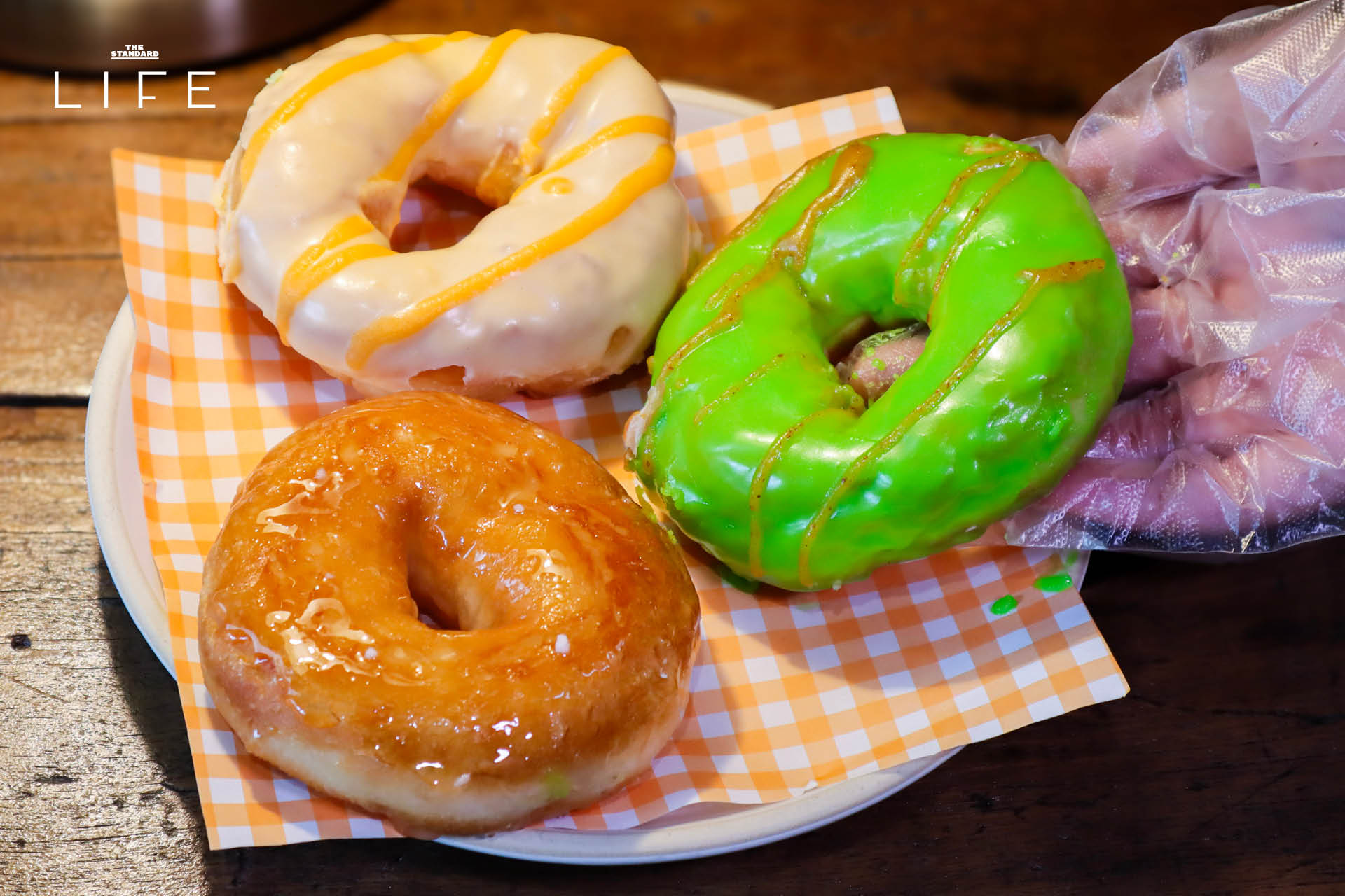 ภาพโดนัทโฮมเมด SODO Donut ที่ทำจากวัตถุดิบท้องถิ่น วางเรียงบนโต๊ะอย่างสวยงาม 12