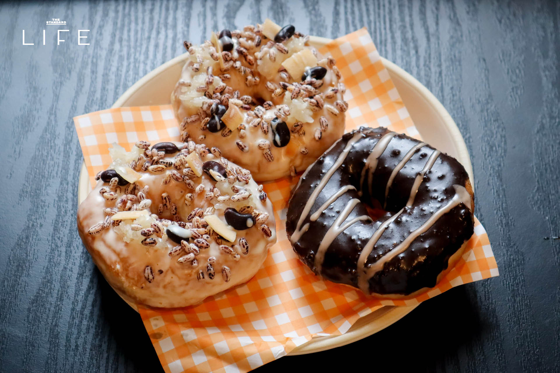 ภาพโดนัทโฮมเมด SODO Donut ที่ทำจากวัตถุดิบท้องถิ่น วางเรียงบนโต๊ะอย่างสวยงาม 14