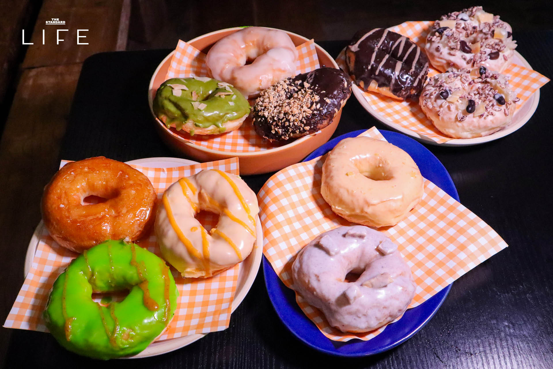 ภาพโดนัทโฮมเมด SODO Donut ที่ทำจากวัตถุดิบท้องถิ่น วางเรียงบนโต๊ะอย่างสวยงาม 4