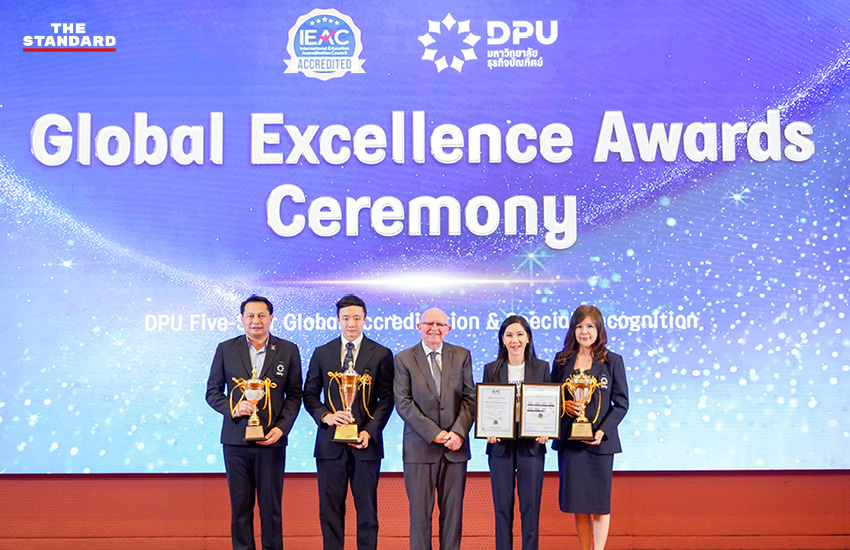 ดร.ดาริกา ลัทธพิพัฒน์ อธิการบดี DPU พร้อมโลโก้มหาวิทยาลัยและรางวัล IEAC 1