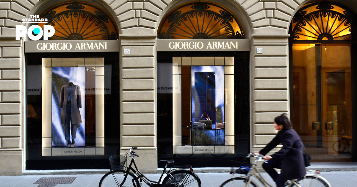ผู้หญิงปั่นจักรยานผ่านหน้าร้าน Giorgio Armani