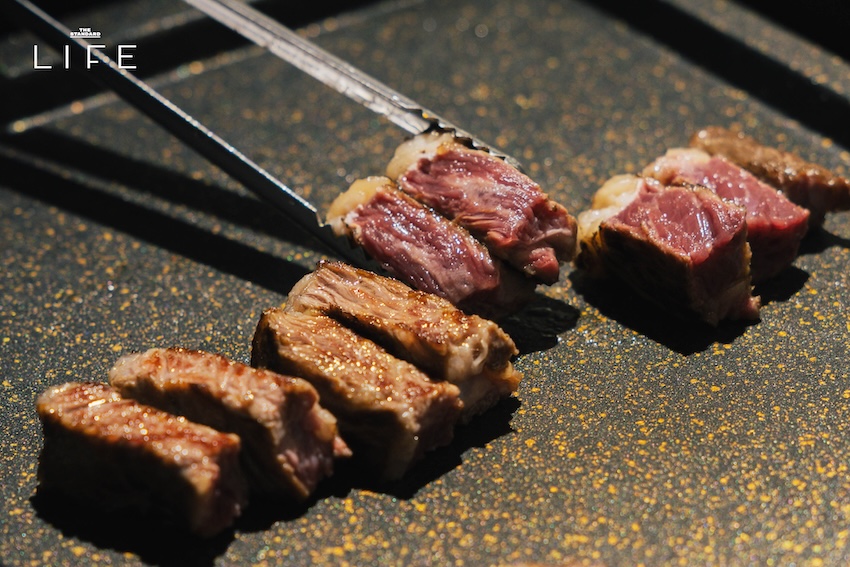 ภาพปิ้งย่างหมูสามชั้นและเนื้อบนเตาถ่านในร้าน HANAM BBQ 3