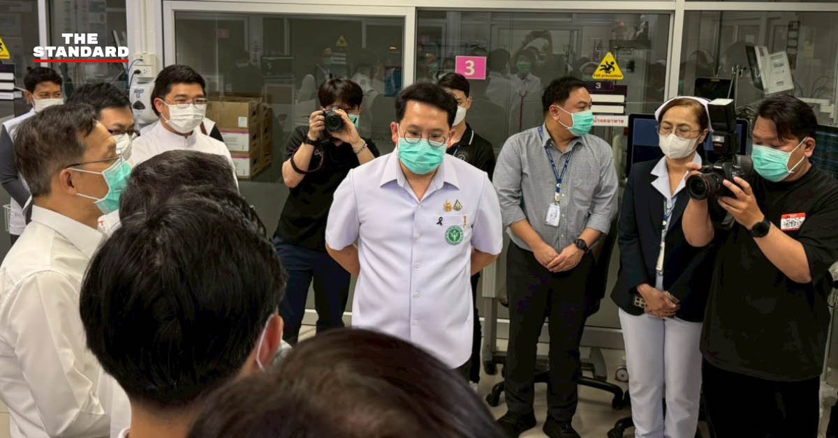 รัฐมนตรีว่าการกระทรวงสาธารณสุขสวมเสื้อเชิ้ตสีขาวและหน้ากากอนามัยสีเขียวขณะลงพื้นที่