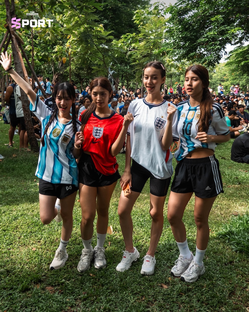 ผู้คนสวมเสื้อบอลและชุดออกกำลังกายร่วมกิจกรรมดูบอลโลกในสวน 10