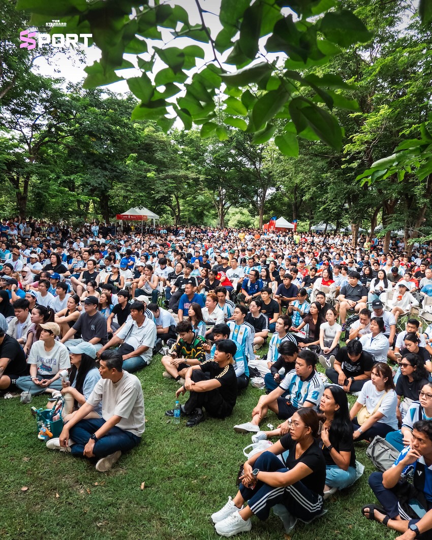 ผู้คนสวมเสื้อบอลและชุดออกกำลังกายร่วมกิจกรรมดูบอลโลกในสวน 11