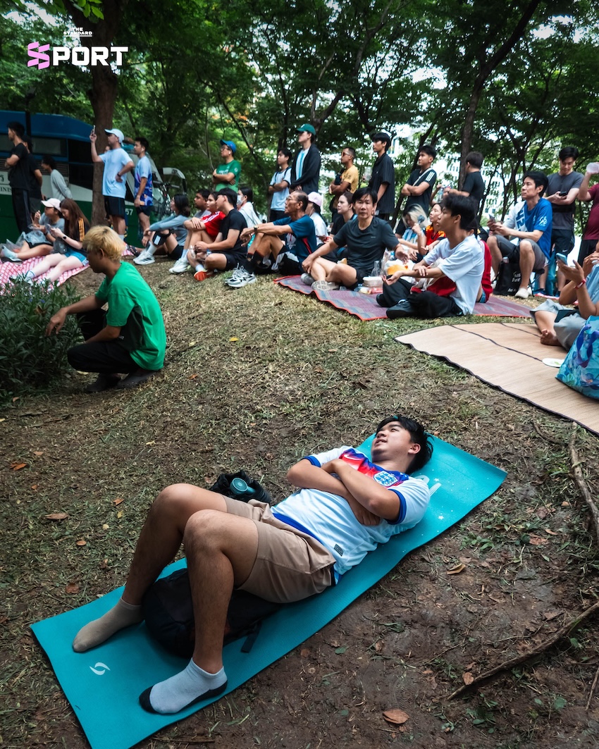 ผู้คนสวมเสื้อบอลและชุดออกกำลังกายร่วมกิจกรรมดูบอลโลกในสวน 5