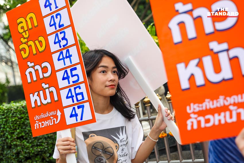 ภาพทีมประกันสังคมก้าวหน้าเดินรณรงค์ถือป้ายหน้าอาคาร SKYY9 5