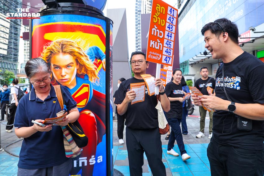 ภาพทีมประกันสังคมก้าวหน้าเดินรณรงค์ถือป้ายหน้าอาคาร SKYY9 9