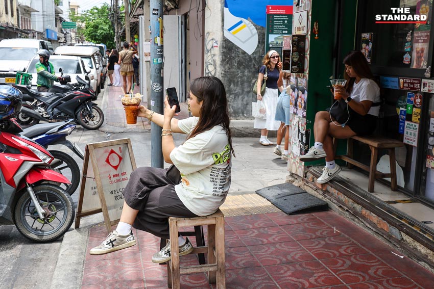 ภาพมุมกว้างของถนนทรงวาด แสดงให้เห็นอาคารเก่าแก่และผู้คนที่เดินเที่ยวชมบรรยากาศ 7
