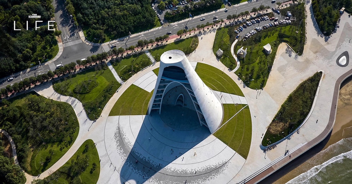 ภาพมุมกว้างของอาคาร Sun Tower ทรงกรวยคว่ำริมทะเลเมืองยานไถ ประเทศจีน